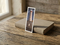 Alone in the Dark fine art bookmark resting on a linen-bound book in soft window light