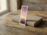 Bali Sunset fine art bookmark resting on a linen-bound book in soft window light