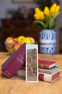 Burnt Mountain fine art bookmark beside a stack of vintage books