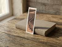 Desert Footprints fine art bookmark resting on a linen-bound book in soft window light