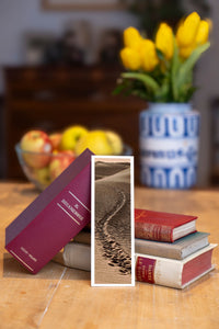 Desert Footprints fine art bookmark beside a stack of vintage books