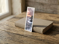 Edge of the World fine art bookmark resting on a linen-bound book in soft window light