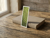 Emerald Terraces fine art bookmark resting on a linen-bound book in soft window light
