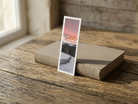 Enrosadira fine art bookmark resting on a linen-bound book in soft window light