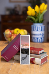 Enrosadira fine art bookmark beside a stack of vintage books