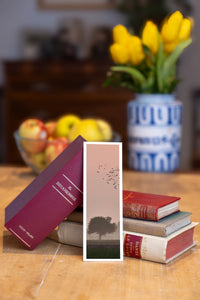Forest Flight fine art bookmark beside a stack of vintage books