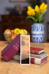 Golden Rise fine art bookmark beside a stack of vintage books