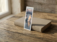 Icy Sunrise fine art bookmark resting on a linen-bound book in soft window light