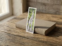 Jungle Tears fine art bookmark resting on a linen-bound book in soft window light
