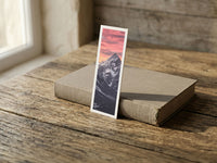 Lonely Mountain fine art bookmark resting on a linen-bound book in soft window light