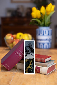 Midnight Sun fine art bookmark beside a stack of vintage books