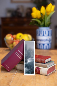 Misty Cliffs fine art bookmark beside a stack of vintage books