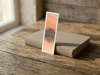 Reflection Twins fine art bookmark resting on a linen-bound book in soft window light