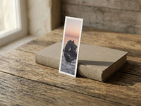 Sea Arch fine art bookmark resting on a linen-bound book in soft window light