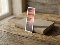 Silent Low Tide fine art bookmark resting on a linen-bound book in soft window light