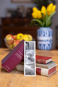 Silver Flowing fine art bookmark beside a stack of vintage books