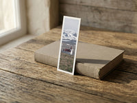 Snowy Chapel fine art bookmark resting on a linen-bound book in soft window light