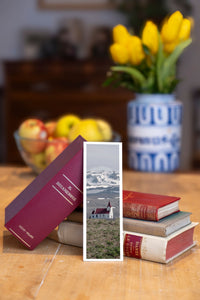 Snowy Chapel fine art bookmark beside a stack of vintage books