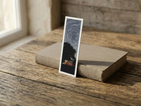 Starry Tree fine art bookmark resting on a linen-bound book in soft window light