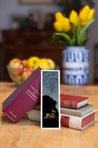 Starry Tree fine art bookmark beside a stack of vintage books