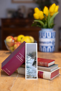 Stormy Cliffs fine art bookmark beside a stack of vintage books