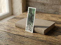 Strong Roots fine art bookmark resting on a linen-bound book in soft window light