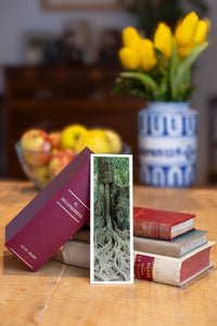 Strong Roots fine art bookmark beside a stack of vintage books