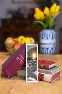 Sunburst fine art bookmark beside a stack of vintage books