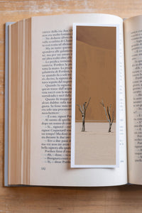 Terracotta fine art bookmark resting in an open book, close-up