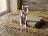The Empty Quarter fine art bookmark resting on a linen-bound book in soft window light