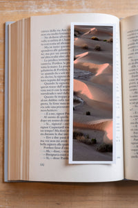 The Empty Quarter fine art bookmark resting in an open book, close-up