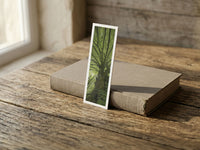 Tree Shepherd fine art bookmark resting on a linen-bound book in soft window light