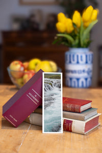 Turquoise Cascade fine art bookmark beside a stack of vintage books
