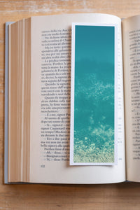 Turquoise Oceania fine art bookmark resting in an open book, close-up
