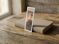 Vingerklip fine art bookmark resting on a linen-bound book in soft window light