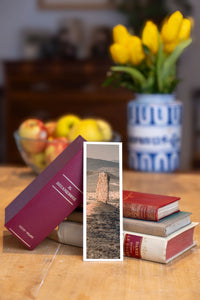 Vingerklip fine art bookmark beside a stack of vintage books
