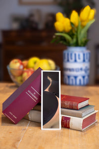 Yin Yang fine art bookmark beside a stack of vintage books